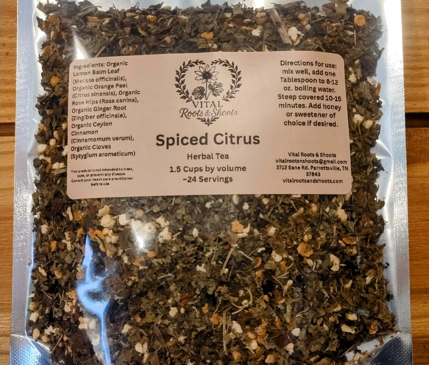 Organic Spiced Citrus Herbal loose leaf tea in a resealable pouch, dried orange peel, lemon balm, and rosehips create a lovely display.