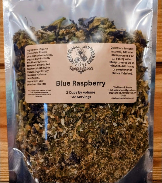 Organic blue raspberry herbal loose leaf tea showing blue butterfly pea flowers mixed with chamomile and red raspberry leaf in a resealable pouch.